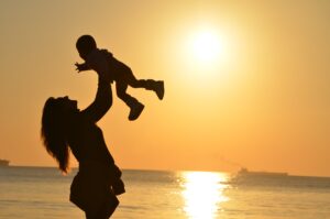Kvinna håller ett barn solnedgång